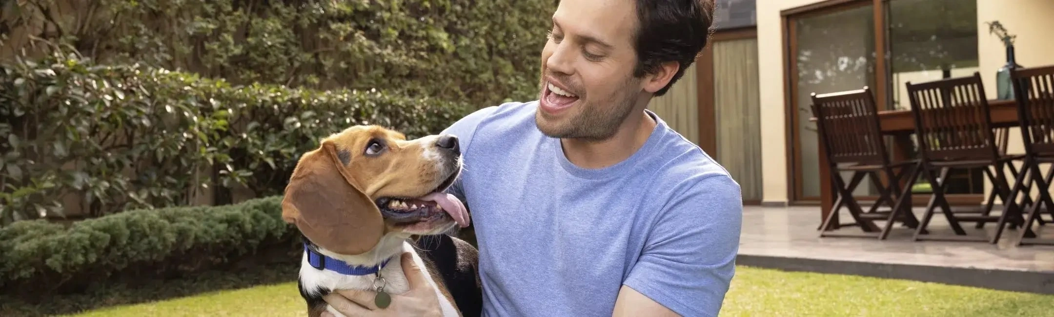 man and dog in backyard