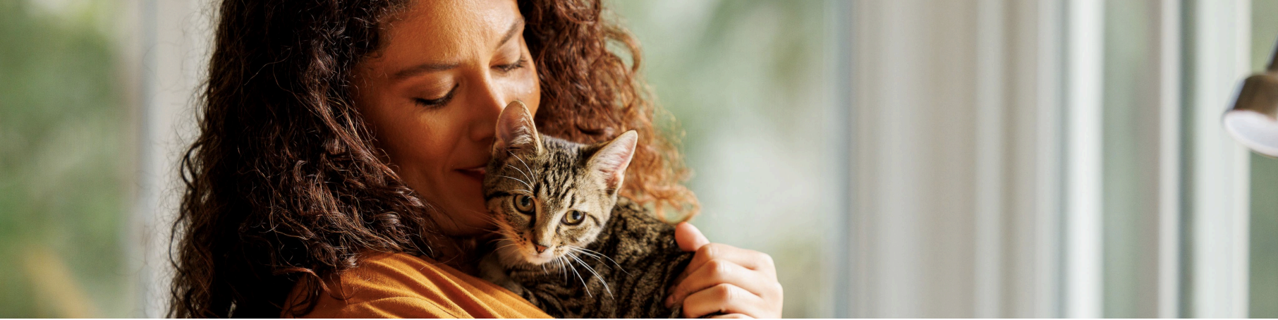 Woman holding a cat for the hero of New Pet Owner Page