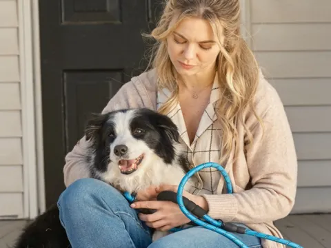 woman sitting on the porch with her dog