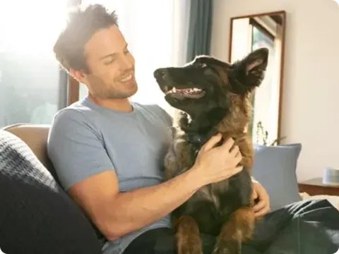 man sitting on the couch with his dog