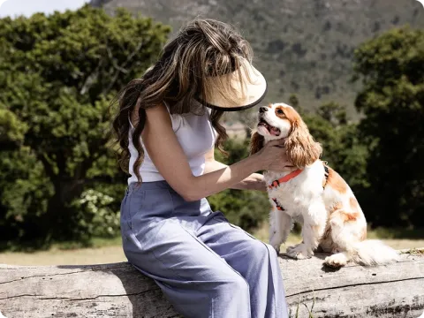 woman with her dog sitting on a log